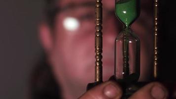 Dolly Shot of Close Up Elderly Scientist Examining Old Hourglass video