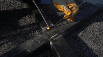 soldador está soldando piezas de metal en fábrica