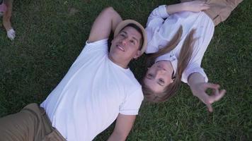 couple lying on the grass. Top view video