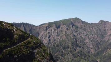 vista aérea do drone das montanhas em um dia ensolarado com pessoas assistindo de um ponto de vista. bela vista panorâmica de diferentes picos de montanhas. viajar pelo mundo e ver a beleza da natureza.