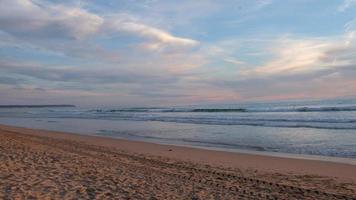 schöner sonnenuntergang am strand mit wolken. Ozean und ruhige Wellen. schöne Pastellfarben. ruhiger und entspannender Moment. video