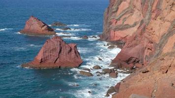Amazing view over the ocean and beautiful brown and red colored rocks. Waves crashing on the cliffs. Island in the middle of the Ocean. Portugal. Travel the world. Vibrant blue colors. video