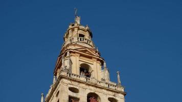 klokken luiden van de moskee kathedraal van cordoba in spanje tijdens een zonnige dag. architectuur. toren van de kathedraal. levendige kleuren. video