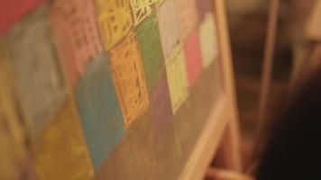 close-up da criatividade da mão da menina desenhando a pintura artística no quadro-negro na educação do lazer infantil por ilustrações de design de giz colorido, rosa, amarelo, verde, azul e felicidade. video
