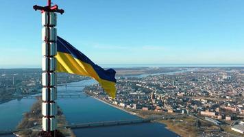 bandiera ucraina che sventola in cima alla torre della riga tv in lettonia. vista aerea a sostegno dell'Ucraina. video
