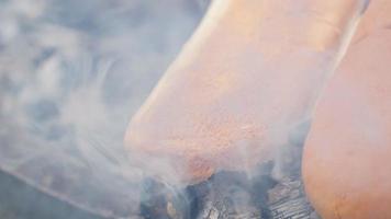 Kochen von Kuhfleischbällchen auf einem Grillholzfeuer