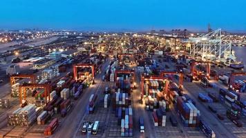 vista aérea timelapse do navio porta-contentores de carga no porto de estaleiro internacional de carga sob o tanque de carregamento do guindaste para o transporte de mercadorias de exportação por navio. video