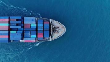 Antenn av smart lastfartyg som transporterar container och kör för exportvaror från lastgårdshamn till andra oceankonceptfraktfartyg på blå himmelbakgrund.