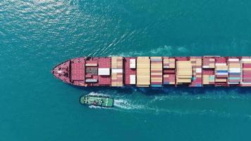 Aerial of smart cargo ship carrying container and running for export  goods  from  cargo yard port to other ocean concept freight shipping ship on blue sky background. video