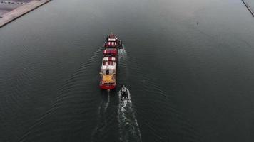 antena de un buque de carga inteligente que transporta un contenedor y se ejecuta para exportar mercancías desde el puerto del patio de carga a otro buque de transporte de carga con concepto oceánico sobre fondo de cielo azul. video