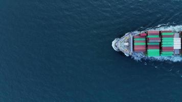Antenne eines intelligenten Frachtschiffs, das Container trägt und für Exportgüter vom Frachthafen zu einem anderen Ozeankonzept-Frachtschiff auf blauem Himmelshintergrund läuft. video