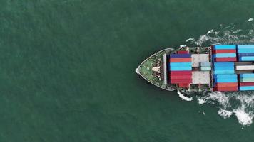 antenne van slim vrachtschip met container en rennen voor exportgoederen van vrachtwerfhaven naar ander oceaanconcept vrachtschip op blauwe hemelachtergrond. video