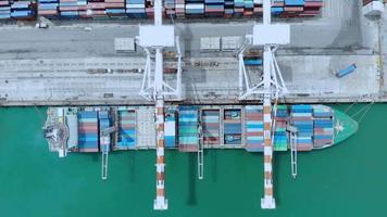 timelapse di vista aerea della nave portacontainer al porto del cantiere internazionale di carico sotto il serbatoio di carico della gru per il trasporto di merci di esportazione via nave. video