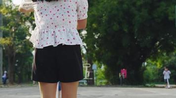 feliz madre e hijos chocando los cinco mientras montan scooters en el parque de verano. niños jugando al aire libre con scooters. actividades de ocio y deportes al aire libre para niños video