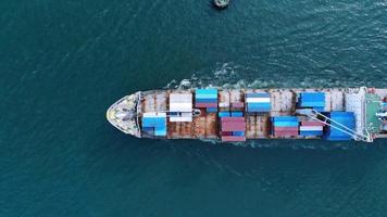 Aerial top view of smart cargo ship carrying container and running for export  goods  from  cargo yard port to other ocean concept freight shipping ship