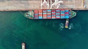 Aerial of smart cargo ship carrying container and running for export  goods  from  cargo yard port to other ocean concept freight shipping ship on blue sky background.