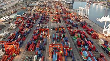 Aerial view timelapse of cargo container ship at the cargo international yard port under crane loading tank for export freight shipping by ship. video