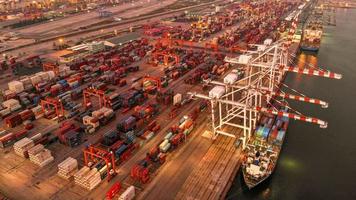 vista aérea timelapse do navio porta-contentores de carga no porto de estaleiro internacional de carga sob o tanque de carregamento do guindaste para o transporte de mercadorias de exportação por navio. video