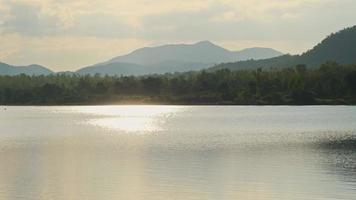 vista sul lago e sulle montagne al tramonto. video