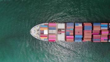 vista aerea dall'alto di una nave da carico intelligente che trasporta container e funziona per l'esportazione di merci dal porto di scalo merci ad altre navi da trasporto merci oceaniche video