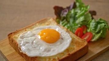 pão caseiro torrado com queijo e ovo frito por cima com salada de legumes no café da manhã