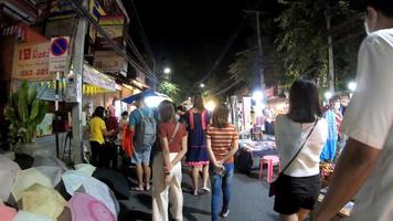 chiang mai, thailand - 6. dezember 2016 - touristen gehen und wählen essen auf dem nachtmarkt in chiang mai, thailand. video