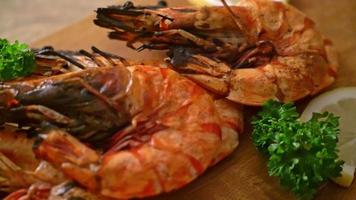 grilled tiger prawns or shrimps with lemon on wood board video