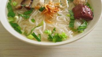 sopa de macarrão de arroz vietnamita com salsicha vietnamita servida de legumes e cebola crocante - estilo de comida asiática video