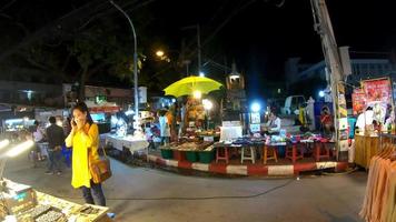 chiang mai, thailand - 6. dezember 2016 - touristen gehen und wählen essen auf dem nachtmarkt in chiang mai, thailand video