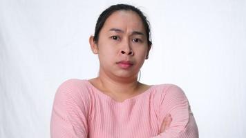 Wütende asiatische Frau, die mit verschränkten Armen steht und im Studio auf weißem Hintergrund in die Kamera schaut video
