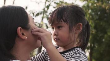 figlia carina che abbraccia e bacia la madre amorevole al tramonto nel parco estivo. festa della mamma. video