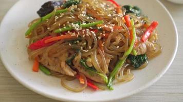 japchae or stir-fried Korean vermicelli noodles with vegetables and pork topped with white sesame - Korean traditional food style video