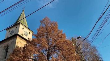 Baratia Church tower in Campulung Muscel, Arges Romania. Medieval Catholic church with monastery and bell tower with cross. Religion and Christianity video