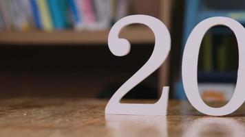 il numero bianco 2022 è posizionato su un tavolo di legno in casa. felice anno nuovo 2022. video