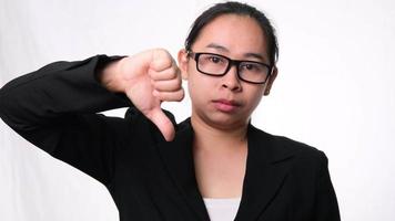 mujer de negocios asiática de pie mostrando un gesto de desagrado con los pulgares hacia abajo sobre fondo blanco en el estudio video