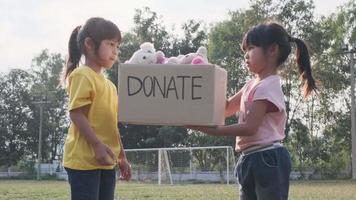 jonge vrijwilligers die een donatiebox geven aan de ontvanger in het park. donatie concept.