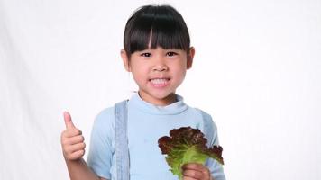 Kinder essen nicht gerne Gemüse. kleines Mädchen, das es hasst, grünen Salat zu essen.