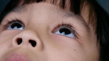 primer plano de una linda niña asiática mirando hacia arriba. video