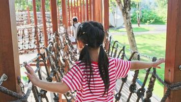 aktives kleines Mädchen, das Spaß auf dem Spielplatz im Freien im Park hat. süßes kleines Mädchen, das auf dem Kinderspielplatz klettert und herunterrutscht. Spielen ist Lernen in der Kindheit. video