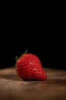 One strawberry on a wood table photo
