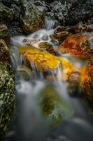 agua que fluye entre las rocas foto