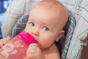 el pequeño bebé está comiendo su comida. alimentos para bebés, fórmula, cuidado del bebé foto