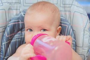 el pequeño bebé está comiendo su comida. alimentos para bebés, fórmula, cuidado del bebé foto