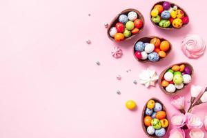 Chocolate easter eggs and decor flat lay for kids easter hunt egg concept on pink background. Sweets in the shape of an egg photo