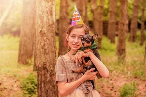 feliz cumpleaños niña con un perro chihuahua negro. feliz cumpleaños foto