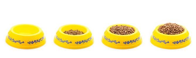 Dog food in yellow plastic bowl isolated on white photo