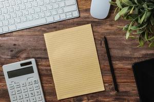 top view  wood table with calculator and notebook working desk at home photo