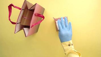main dans des gants en latex wapping une boîte-cadeau avec du tissu