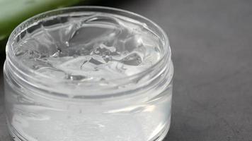 Fresh aloe vera sliced and liquid gel in plastic container on white background video