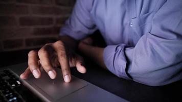 close-up op de hand van een man die de muis van een laptop gebruikt, licht veranderend video